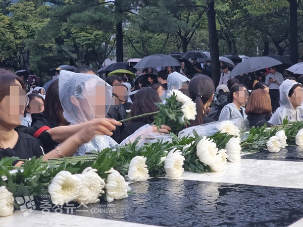 행사가 끝난 뒤 연단 위에 국화꽃이 놓이고 있다.