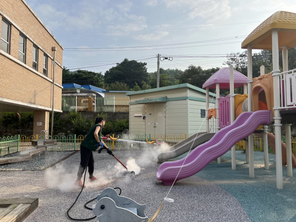 감성초등학교 병설유치원에서 스팀 소독 장비로 모래 놀이터 및 우레탄 바닥재를 소독하고 있다.