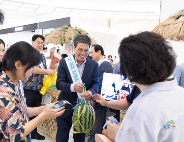 지난 7월 22일 열린 현대아울렛 판촉행사에서 김돈곤 군수가 소비자들에게 청양에서 생산된 수박을 건네고 있다.