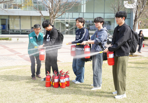 학생들이 16일 교내 중앙공원에서 ‘한기대 안전 히어로’ 훈련용 소화기 체험에 참여했다.