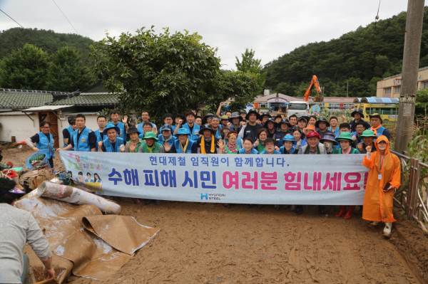 현대제철 임직원 봉사단, 전국금속노조 충남지부 현대제철지회, 마중물주부봉사단, 당진제철소 기장단협의회 등 참여자들이 복구 작업을 마치고 피해 시민을 격려하기 위한 현수막을 들고 기념촬영