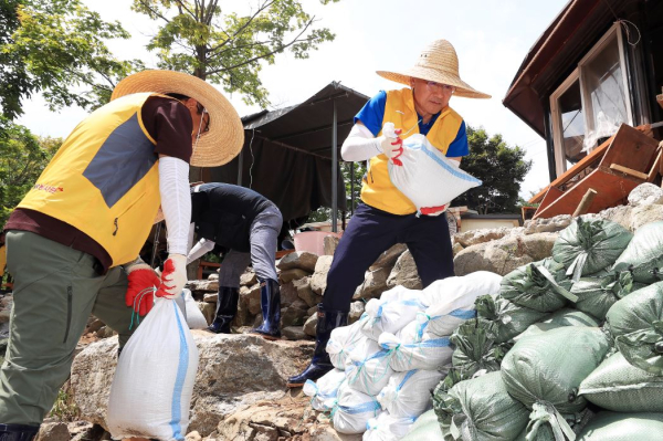 23일 충남 서산시 수해 피해 마을에서 환경정비 활동 중인 이성해 국가철도공단 이사장(오른쪽)과 본사 직원봉사단