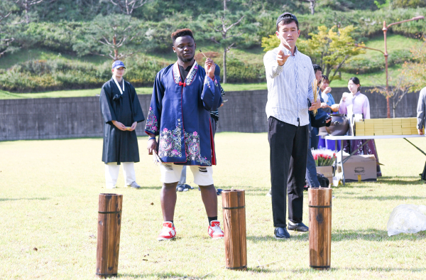 유학생들이 투호 던지기 체험을 즐기고 있다.
