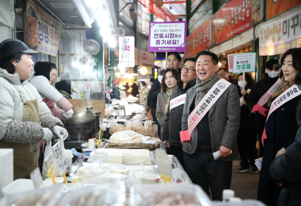 구 관계자들이 시장 상인에게 인사를 건네고 있다