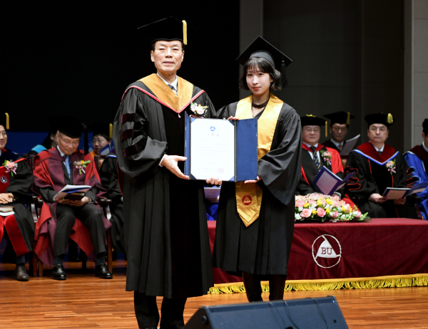 후지타 유키 학생이 총장상을 받고 기념촬영을 하고 있다.