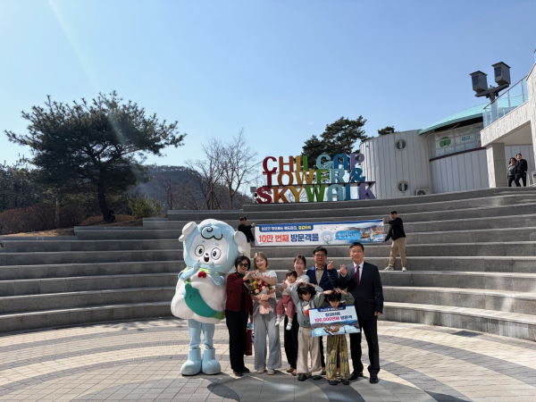 지난 22일 청양 칠갑타워에서 열린 10만 방문객 돌파 기념 이벤트에서 강희선 관광진흥과장(오른쪽 끝)이 10만 번째 방문객 임연옥 씨(왼쪽에서 다섯 번째)에게 기념품을 전달한 뒤 기념 촬영