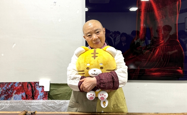 정관스님이 배재대 마스코트 나섬이 인형을 안고 사진 촬영하고 있다.