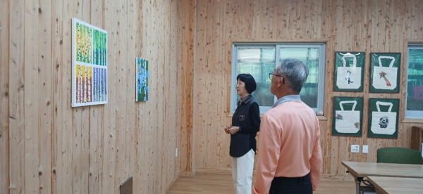 17일, 국립예산치유의숲을 방문한 이용객들이 전시 프로그램에 참여하여 작품을 감상하고 있다.