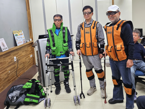 시야 제한, 관절기능 저하 등을 반영한 노화체험 장비를 착용하고 보행 체험하고 있다