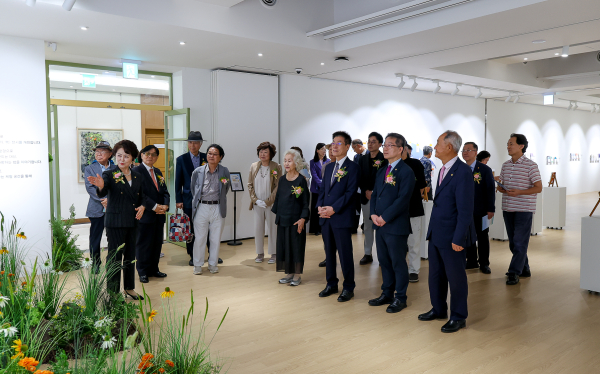 문현미 관장이 '지구야 사랑해'展 개막행사 참석자들에게 전시 작품을 소개하고 있다.